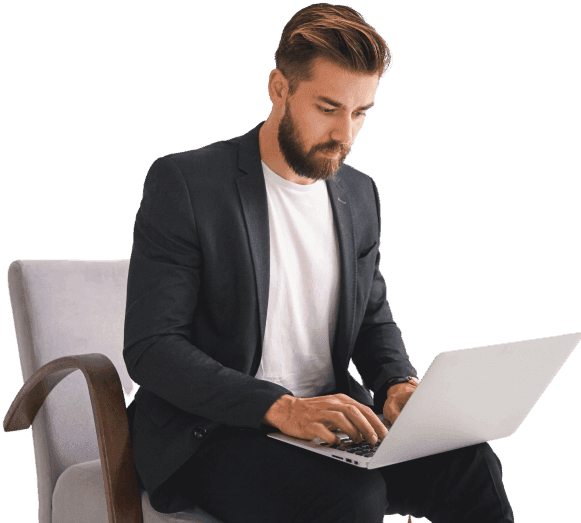 A man in a suit working on a laptop